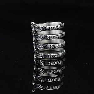Gothic punk titanium steel rib cage ring with vintage silver finish on black background