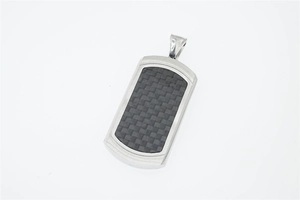 Detailed view of dog tag pendant with black carbon fiber inlay and brushed steel texture
