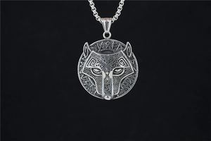 Détail du pendentif tête de loup viking avec runes nordiques et texture métal argenté
