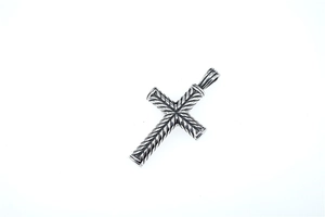Détail du pendentif en croix avec texture torsadée classique et finition oxydée