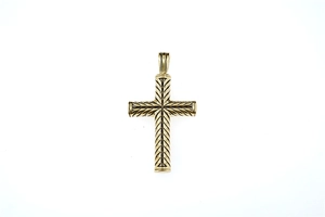 Détail du pendentif croix dorée avec gravure complexe de motif à chevrons sur métal