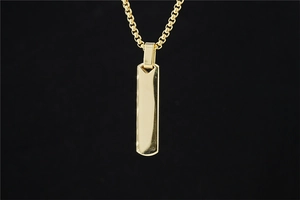 Close-up of polished gold rectangular bar pendant with classic box chain on black background