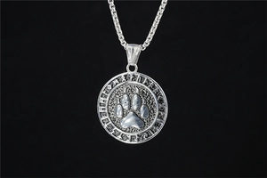Macro shot of a Viking bear paw pendant with Nordic runes on a stainless steel box chain