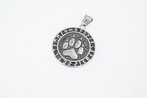 Macro detail of Nordic Viking bear paw pendant with runic alphabet engraving
