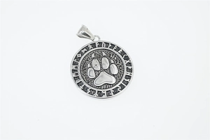 Macro shot of vintage Viking bear paw pendant with intricate Nordic Runic symbols