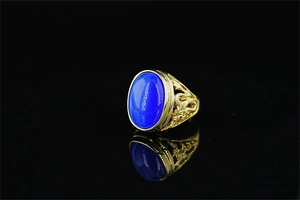 Detailed view of hollow dragon engraving on golden ring with blue tiger eye stone