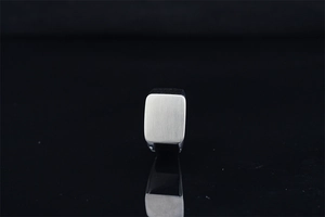 Macro shot of silver square signet ring with brushed metal texture and matte finish