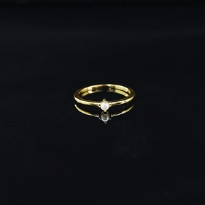 Bague élégante minimaliste en titane doré avec une petite perle blanche sur fond noir