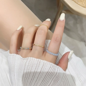 Set of four stacked gold rings with blue crystal beads for a minimalist boho look