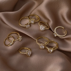 Lot de 8 bagues dorées réglables avec zircons cœur et carrés sur tissu en soie brune