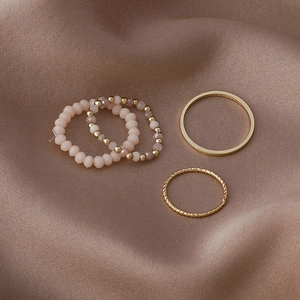 Detail of pink crystal beads and golden metal rings on a luxury brown satin fabric