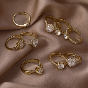 Ensemble de bagues dorées avec zircons géométriques sur fond de satin marron élégant