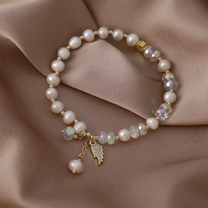 Freshwater pearl bracelet with crystal beads and a golden zircon angel wing charm