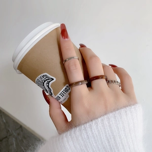 Close-up of a 4-piece acrylic and silver ring set featuring marble and amber patterns