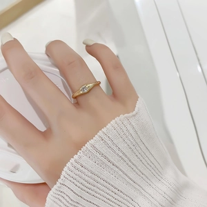 Gros plan d'une bague dorée avec zircon rond à la main tenant une tasse de café