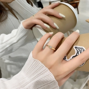 Gros plan d'une bague dorée en zircone portée en tenant une tasse de café blanc