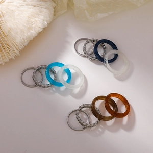 Flat lay of a 12-piece ring set with silver-tone metal and colorful resin bands