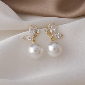 Boucles d'oreilles papillon en perles dorées avec cristaux zircons sur fond de soie