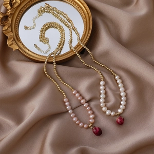 Handmade real dried rose bud pendant necklace with gold beads and pearls on satin backdrop