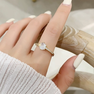 Gros plan d'une bague dorée élégante avec un grand zircon rond et pavage de diamants