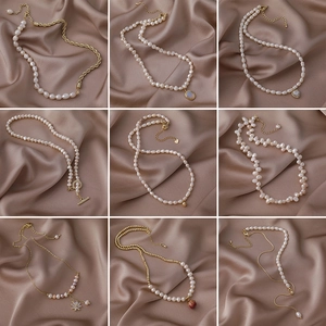 Nine vintage French Baroque freshwater pearl necklaces with gold metal charms