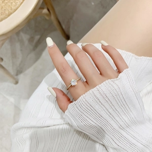 Gros plan d'une bague dorée avec un grand solitaire et un anneau serti de diamants