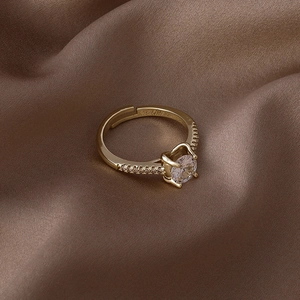 Vue macro d'une bague ajustable dorée avec zircon et pavage sur tissu en soie
