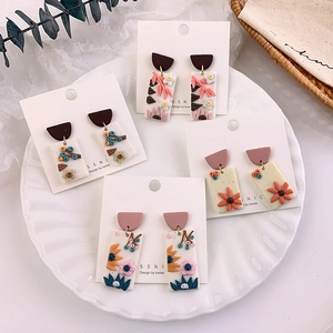 Detail of four handmade polymer clay floral rectangle earrings with 3D embossed petals