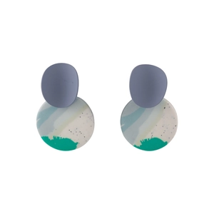 Macro shot of geometric clay earrings with blue oval and multi-color abstract round pendants
