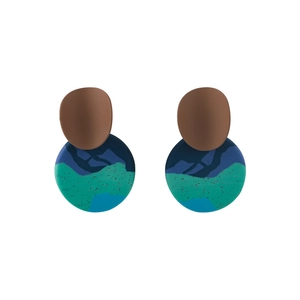 Detail view of abstract handmade clay earrings with blue and green marble patterns