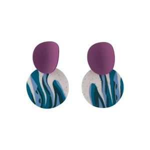 Detailed macro view of purple and blue marble pattern clay earrings with round pendants