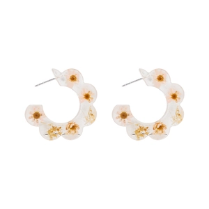 Detailed view of C-shaped resin earrings with embedded real yellow dried flower petals