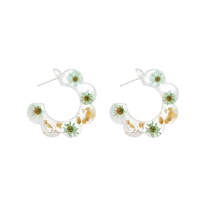 Detail of C-shaped resin hoop earrings with embedded green and orange dried flowers
