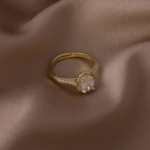 Gros plan d'une bague dorée réglable ornée d'un zircon ovale et d'un halo de cristaux