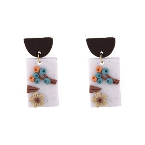 Detail view of handmade floral earrings with clay flowers and berry motifs in retro style