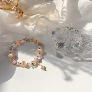 Bracelets en perles de cristal colorées avec breloques fleurs en tons orange et bleu doux