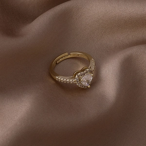 Gros plan d'une bague en zircon en forme de cœur sur un tissu en satin marron luxueux