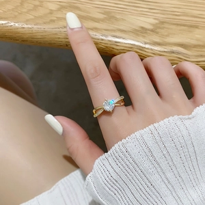 Gros plan d'une bague géométrique dorée avec un grand zircon et des anneaux entrelacés