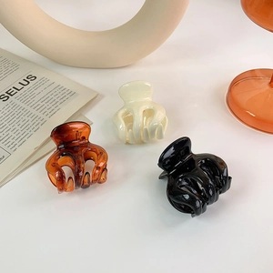 Three-piece small hair claw clip set in amber, cream, and black glossy resin finish