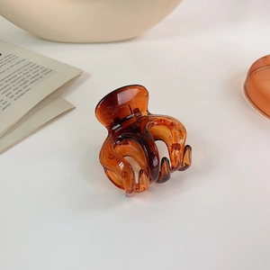 Detailed macro view of the amber resin hair claw clip with its durable metal spring