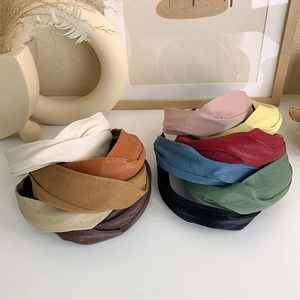 Nahaufnahme von breiten geknoteten PU-Leder-Haarreifen in vielen Retro-Farben