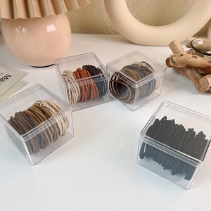 Detailed macro view of elastic hair ties in brown tones inside clear storage boxes