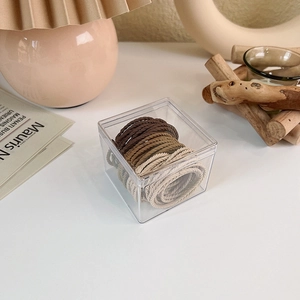 Neutral earth tone seamless hair ties set in a clear acrylic storage container box