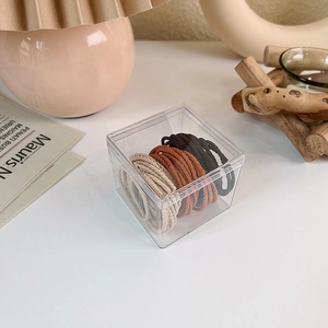 Macro shot of seamless elastic hair ties in neutral coffee tones in a storage box