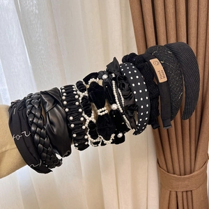Detail view of assorted black headbands with pearls, velvet textures and knotted designs
