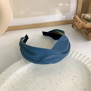 Detailansicht des dunkelblauen PU-Leder-Stirnbands mit Knotendesign auf einem Teller