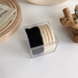 Neutral plush hair scrunchies set in clear square acrylic box with minimal wooden decor
