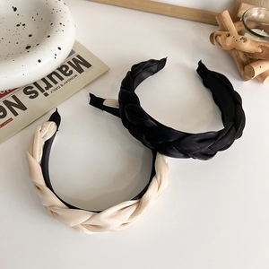 Détail de serre-têtes tressés en satin noir et beige avec texture de soie lisse