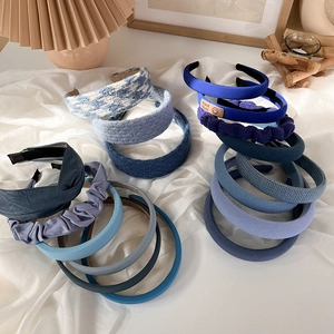 Detailed close-up showing various blue fabric headbands with knit and plaid textures