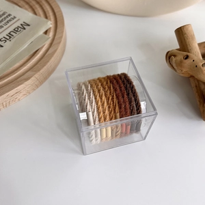 Detail shot of brown gradient hair ties in a transparent acrylic storage box